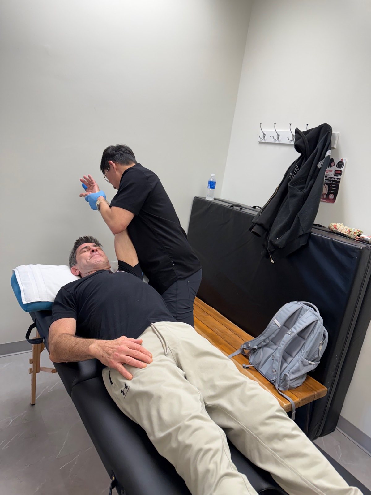 Brian performing hands-on joint mobilization on a patient's hip and leg